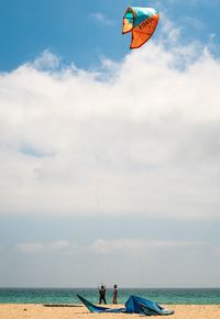 People on sea shore against sky