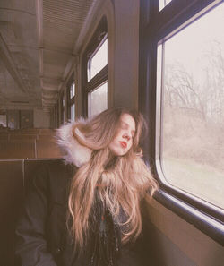 Portrait of teenage girl looking through window