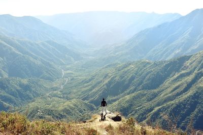 Rear view of man on landscape against mountains