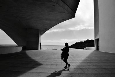 Full length of silhouette woman walking on building terrace