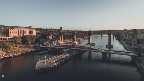 Bridge over river in city against clear sky