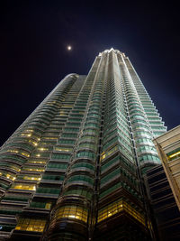 Low angle view of illuminated buildings against sky at night