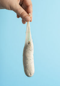 Close-up of hand holding ice cream over white background