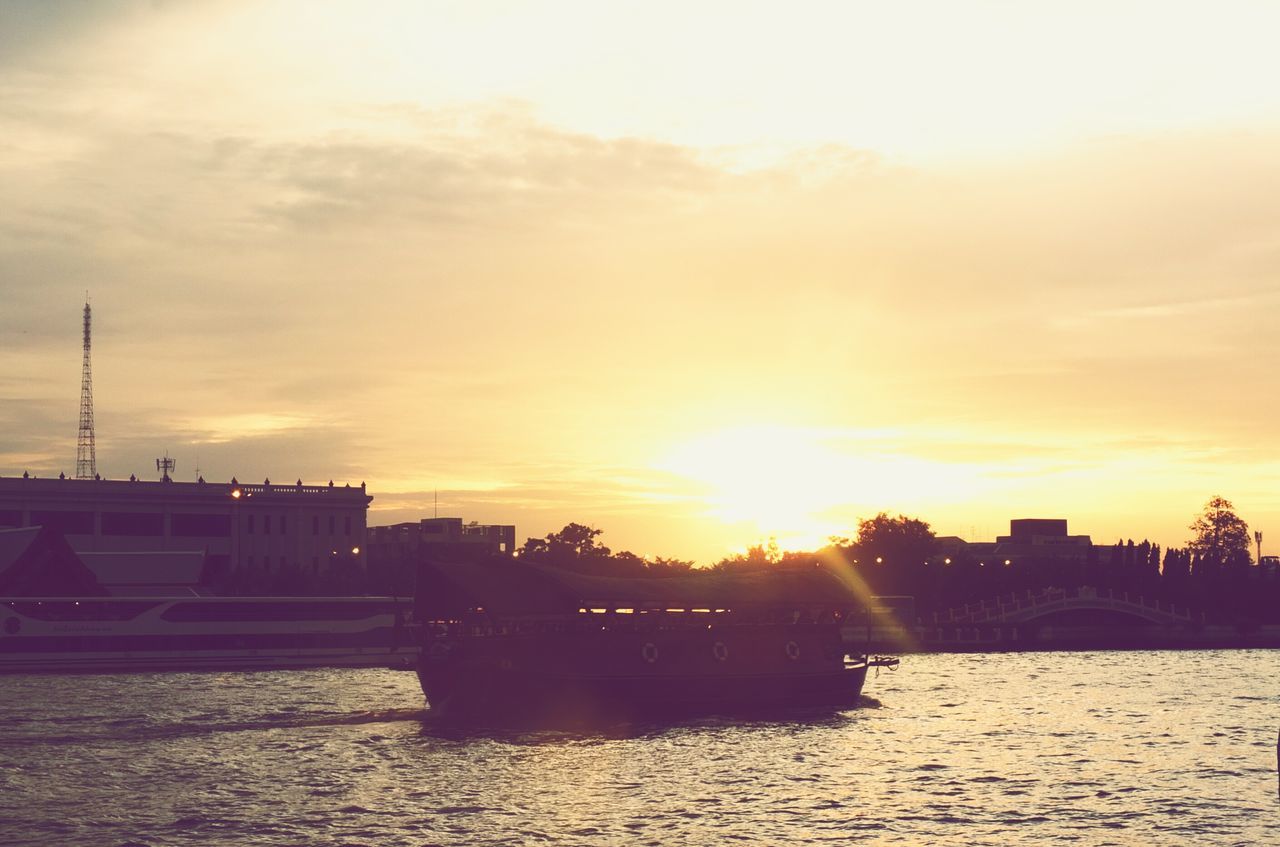 sunset, sun, water, architecture, built structure, building exterior, waterfront, sky, river, silhouette, orange color, sunlight, cloud - sky, transportation, beauty in nature, scenics, nature, city, sunbeam, tranquil scene