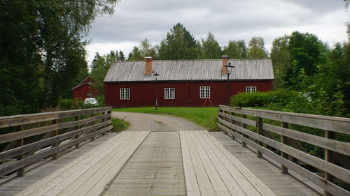 House amidst trees and buildings against sky