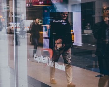 Reflection of men on glass window