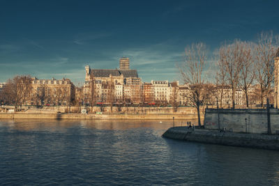 River by buildings against sky in city