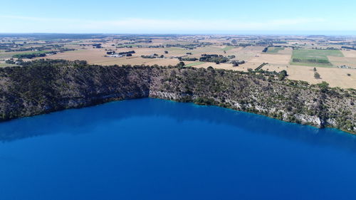 Aerial view of swimming pool by lake against sky