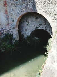 Arch bridge seen through hole in wall