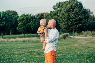 Full length of father and son on field