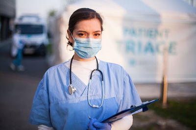 Portrait of doctor wearing mask standing outdoors