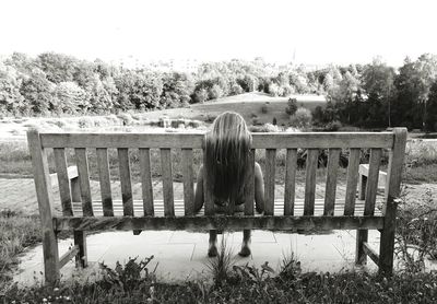 Rear view of woman against plants on field