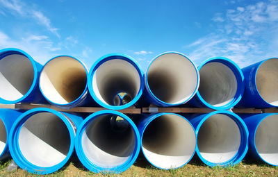 Pipes on grass against blue sky