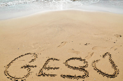 High angle view of text written on sandy beach