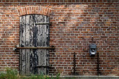 Closed door amidst brick wall
