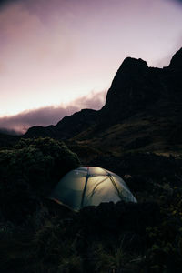 Illuminated tent with purple sky during blue hour while backpacking in haleakala crater, maui.