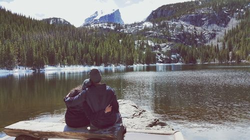 Rear view of couple sitting on bench at bear lakes