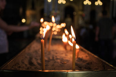 Lit candles in box at church