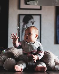 Full length of boy sitting on sofa