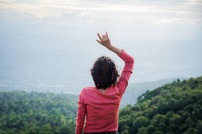 Rear view of woman standing against sky