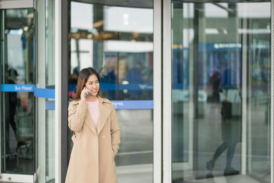 Woman standing on mobile phone in office