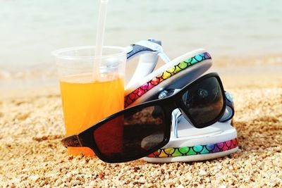 Close-up of sunglasses on glass at beach