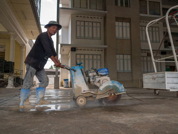 Man working with umbrella standing outside building