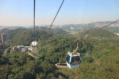 Overhead cable car over mountains against clear sky