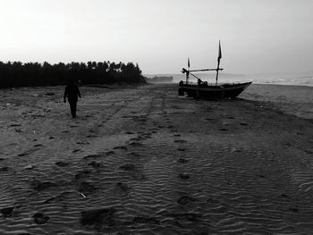 Rear view of silhouette man on beach against sky