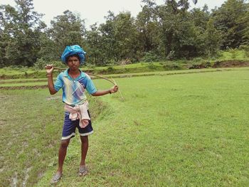 Full length portrait of smiling girl standing on field