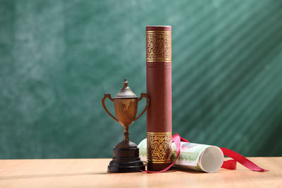 Close-up of trophy with diploma on desk