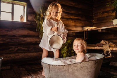 Two little girls in the bath smiling