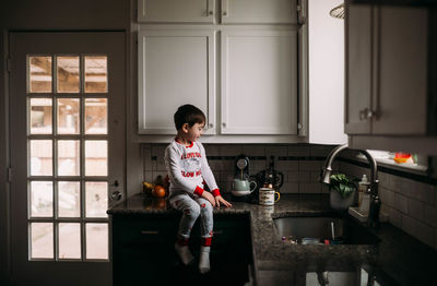 Full length of woman sitting at home