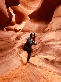 Woman standing by rock formations