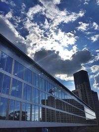 Low angle view of modern building against cloudy sky