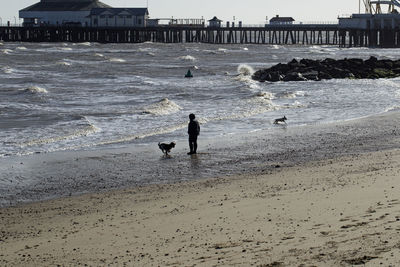 People on beach by sea against sky