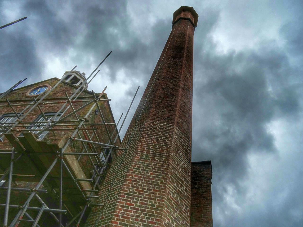 architecture, low angle view, built structure, sky, building exterior, cloud - sky, cloudy, construction site, industry, crane - construction machinery, development, cloud, factory, construction, building, weather, tall - high, incomplete, day, overcast