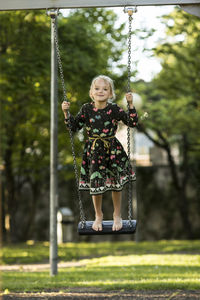 Portrait of smiling girl swinging on swing