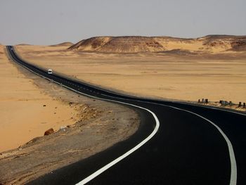 Road on desert against clear sky