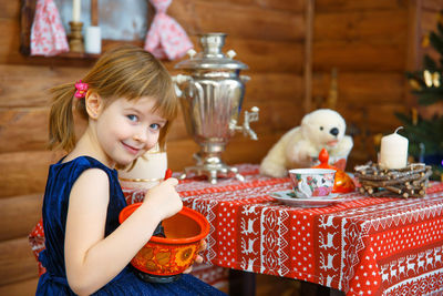 Portrait of cute girl smiling while sitting on table