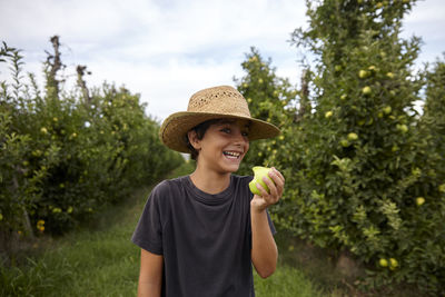 Smiling boy eating an apple from the apple farm