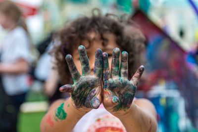 Close-up of girl showing colorful hands