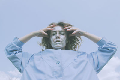 Low angle view of man wearing mask against white background