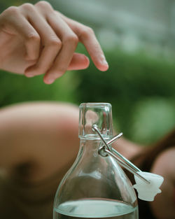 Close-up of hand holding glass bottle