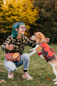 Portrait of woman with dog on grassy field