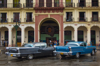 People on street against buildings in city