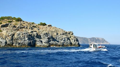 Motorboat sailing on sea along the coastline