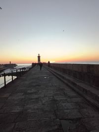 Silhouette bird flying over sea against sky during sunset