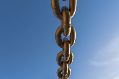 Chain hanging against blue sky
