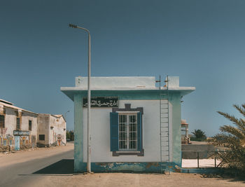 Street by building against clear blue sky